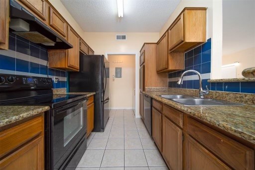 8293 Sands Point Drive, Unit 185 Houston, TX 77036 - Photo 9 of 20 a kitchen with stainless steel appliances granite countertop a stove a sink and a refrigerator