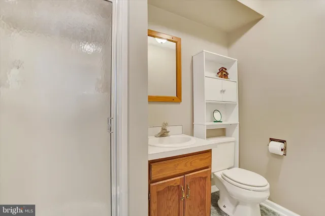 a bathroom with a granite countertop toilet sink and mirror