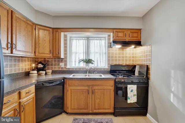 a kitchen with stainless steel appliances a sink stove and cabinets