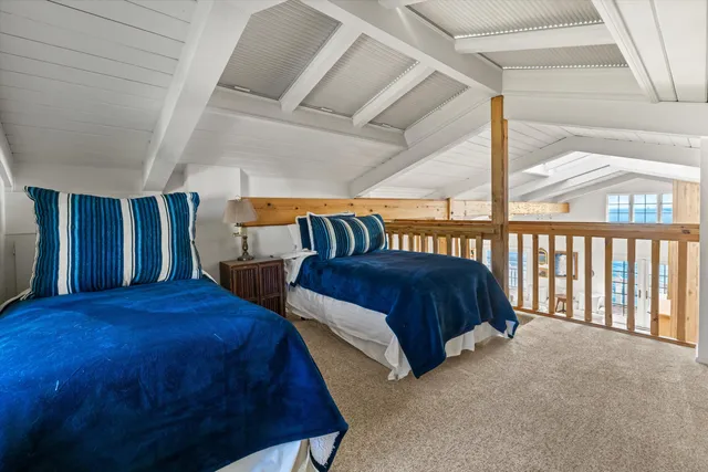 a spacious bedroom with two beds and a window