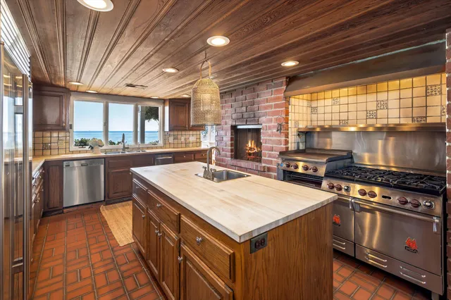 a kitchen that has a sink a stove and a refrigerator