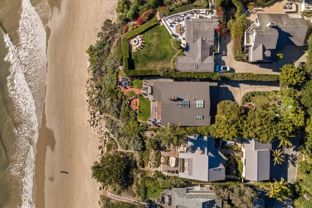 aerial view of a house with a yard and large tree