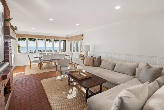 a living room with furniture wooden floor and a large window