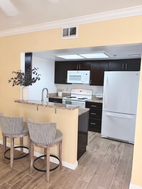 43376 Cook Street, Unit 87 Palm Desert, CA 92211 - Photo 13 of 35 a kitchen with kitchen island a stove a sink and a refrigerator
