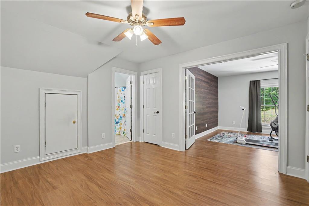537 Old Collins Road Hoschton, GA 30548 - Photo 28 of 42 a view of an empty room with wooden floor and a ceiling fan