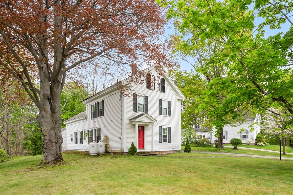 10 Maple Street Sturbridge, MA 01566 - Photo 4 of 40 a view of a white house with a big yard and large trees
