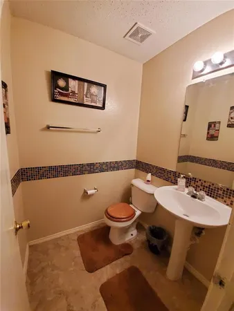 a bathroom with a toilet a sink and mirror