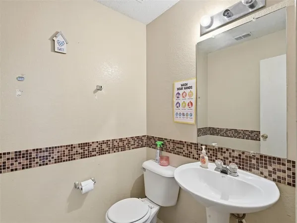 a bathroom with a sink mirror and toilet