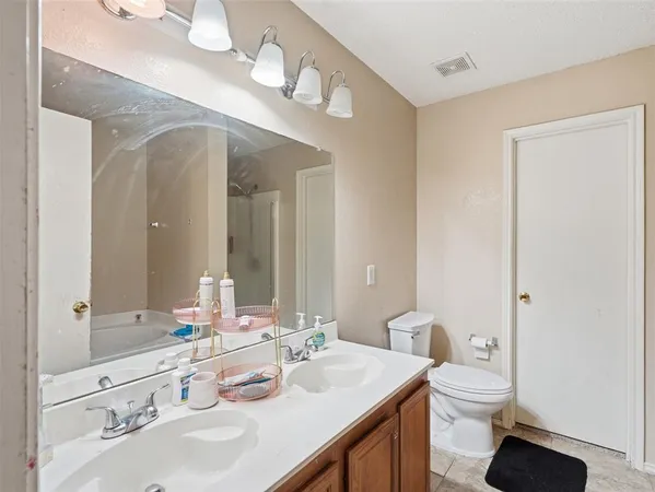a bathroom with a granite countertop double vanity sink and a mirror