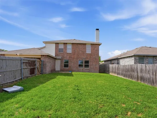 a view of a house with a yard and wooden fence