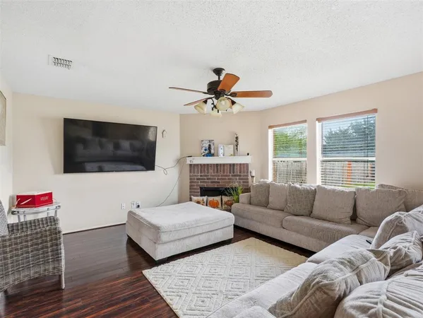 a living room with furniture a flat screen tv and a fireplace