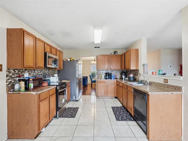 a large kitchen with stainless steel appliances kitchen island granite countertop a sink and cabinets
