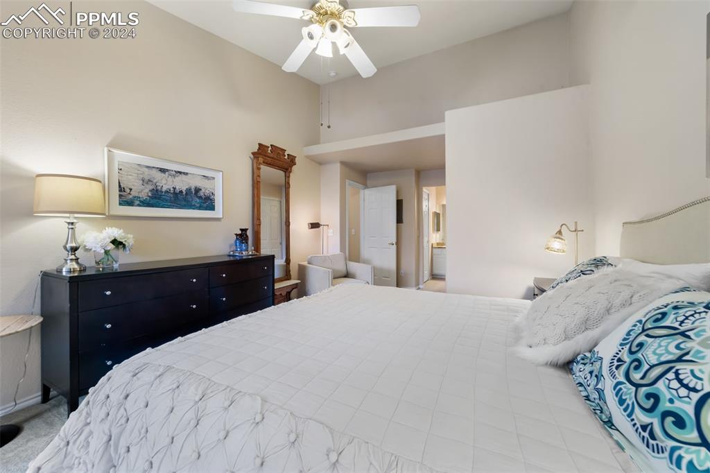 3715 Riviera Grove, Unit 201 Colorado Springs, CO 80922 - Photo 11 of 32 a bedroom with a bed and a chandelier