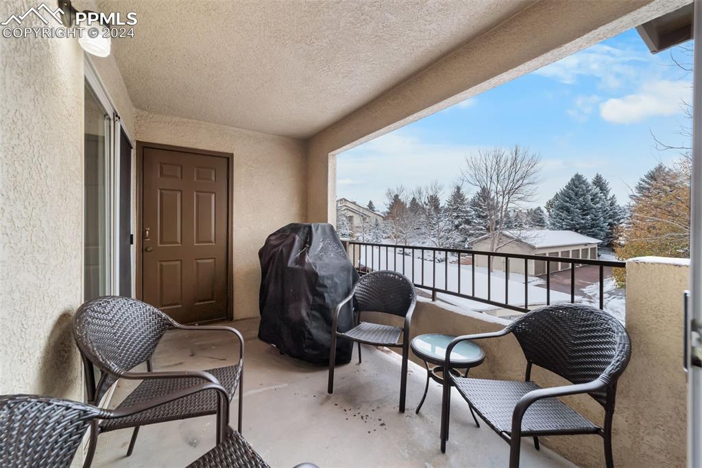 3715 Riviera Grove, Unit 201 Colorado Springs, CO 80922 - Photo 19 of 32 a balcony with wooden floor and outdoor seating