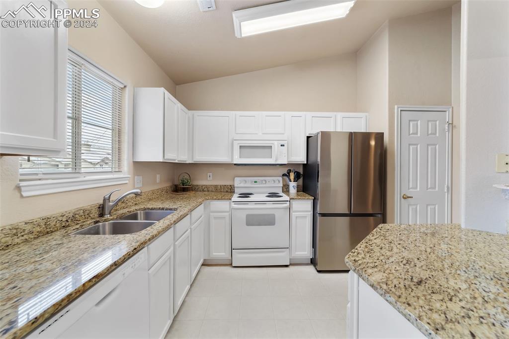 3715 Riviera Grove, Unit 201 Colorado Springs, CO 80922 - Photo 6 of 32 a kitchen with a sink stove and refrigerator