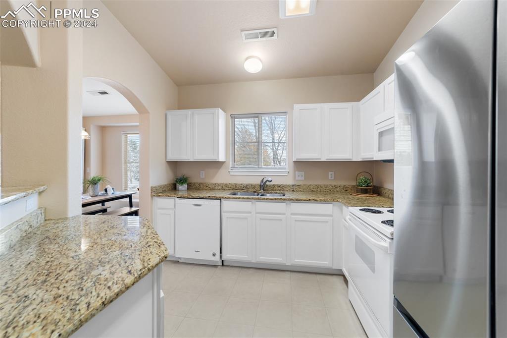 3715 Riviera Grove, Unit 201 Colorado Springs, CO 80922 - Photo 8 of 32 a kitchen with granite countertop a sink stove and cabinets