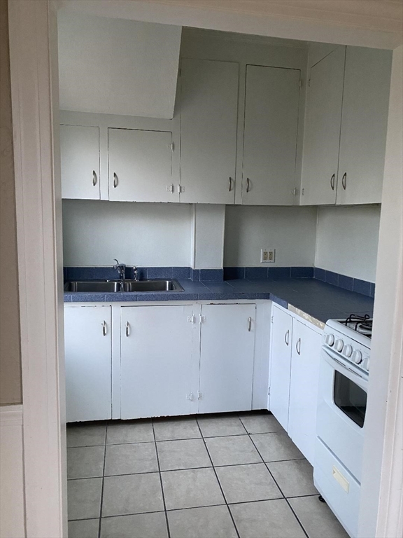 147 Stetson Street, Unit 2 Fall River, MA 02720 - Photo 4 of 8 a kitchen with white cabinets