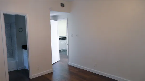 an empty room with wooden floor & closet