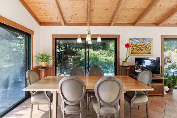a living room with furniture a flat screen tv and floor to ceiling window