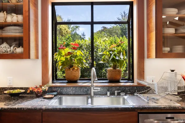 a bathroom with a granite countertop sink toilet and painting on the wall