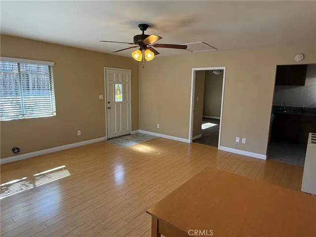 a view of an empty room with window and wooden floor