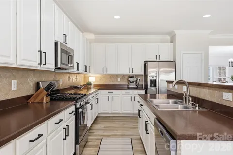 a kitchen with stainless steel appliances granite countertop a sink stove and cabinets