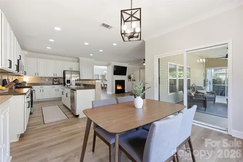 a living room with stainless steel appliances furniture dining table and wooden floor