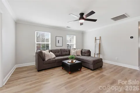 a living room with furniture a window and a ceiling fan