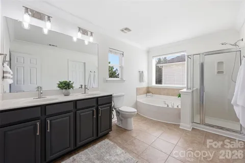 a spacious bathroom with a bathtub shower sink mirror and toilet
