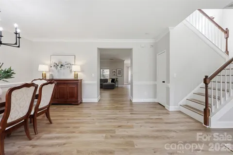 a view of a hallway with wooden floor and furniture