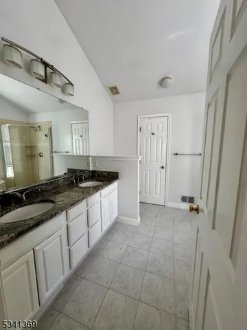 a large kitchen with a granite countertop sink and a refrigerator