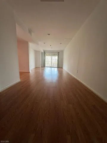 a view of a room with wooden floor and window