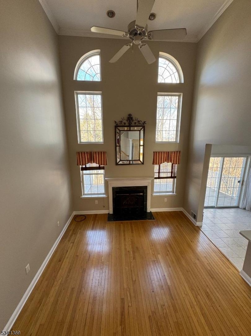 10 Hopkinson Court Bernards, NJ 07920 - Photo 2 of 17 an empty room with wooden floor a fireplace and windows
