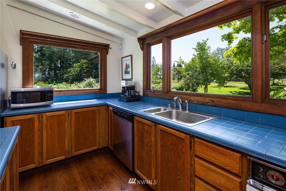 5413 Barr Road Ferndale, WA 98248 - Photo 14 of 40 a kitchen with stainless steel appliances wooden cabinets a sink and a large window