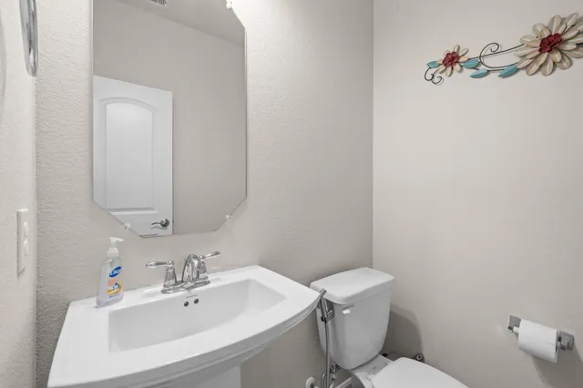 a bathroom with a sink mirror and toilet