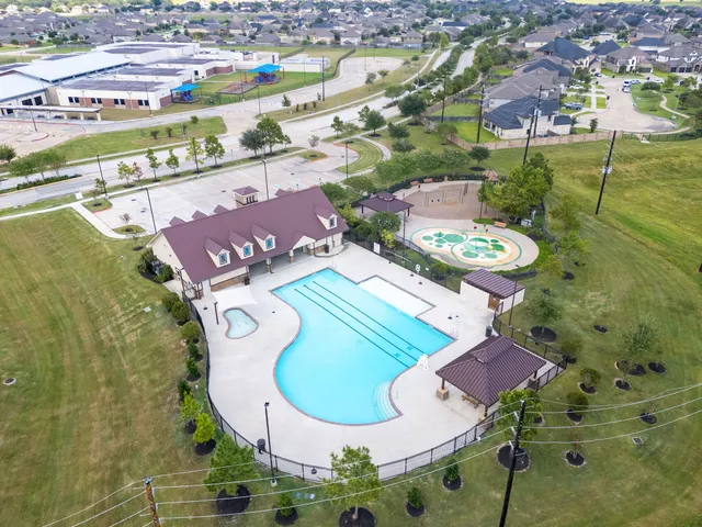 an aerial view of residential houses with outdoor space and swimming pool