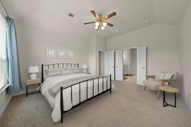 a spacious bedroom with a bed and a chandelier