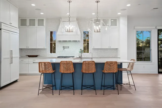 a large kitchen with granite countertop a table chairs sink and cabinets