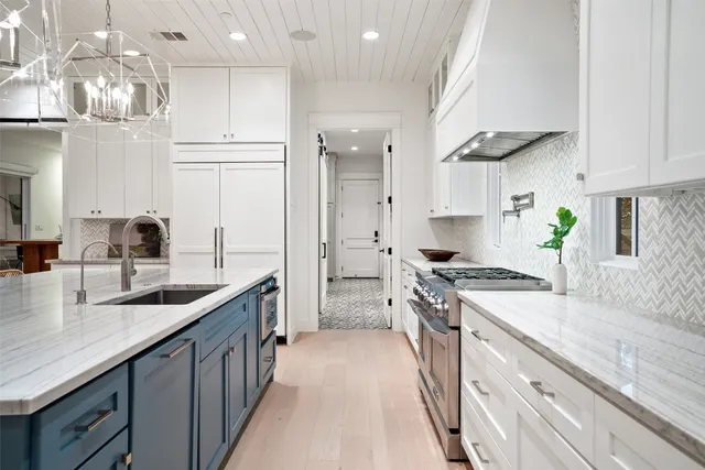 a kitchen with stainless steel appliances granite countertop a sink a stove and a refrigerator