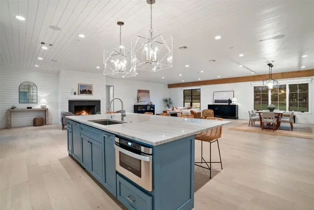 a kitchen with kitchen island a sink counter top space and stainless steel appliances