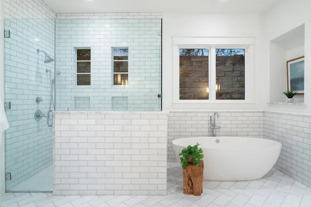 a bathroom with a tub a potted plant