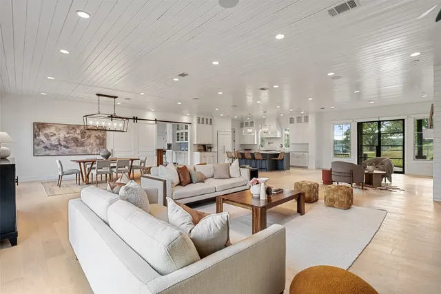 a living room with furniture kitchen view and a large window