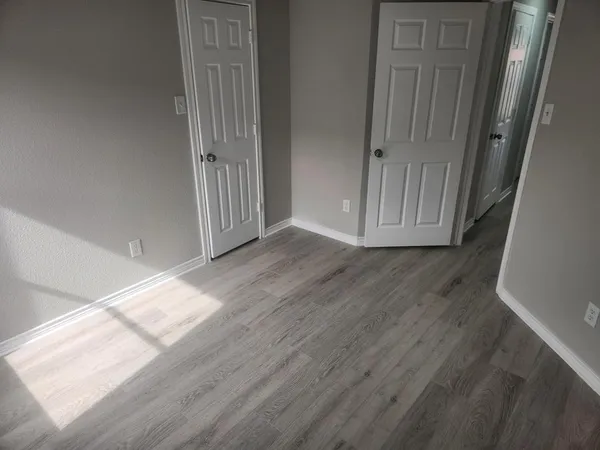 a view of a hallway with wooden floor