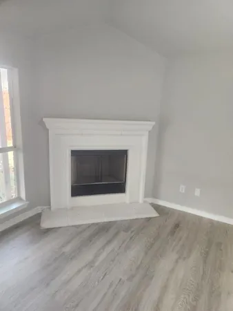 an empty room with wooden floor and fireplace