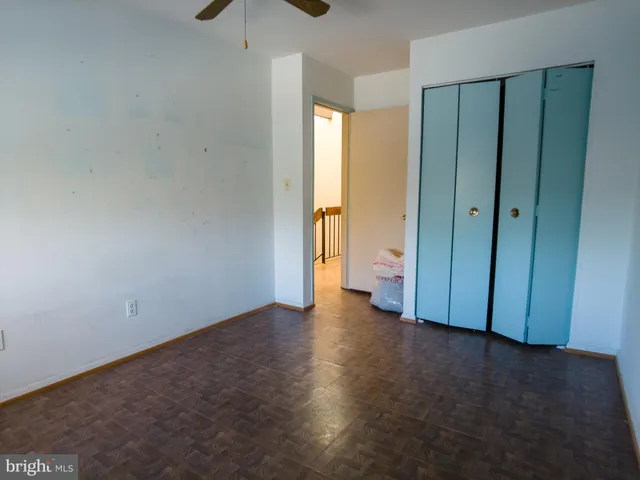 an empty room with a window and a ceiling fan
