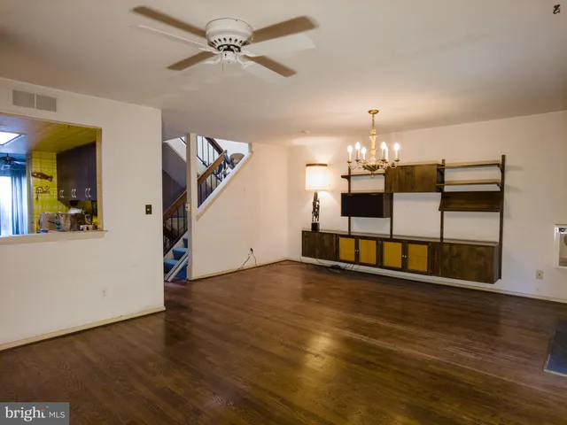 a view of a kitchen with wooden floor and a ceiling fan