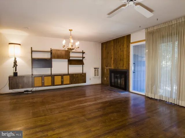 a view of a livingroom with wooden floor fireplace and window