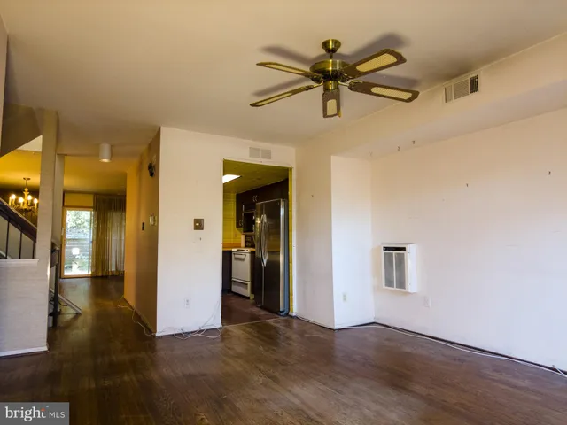 a view of a livingroom with a ceiling fan and wooden floor