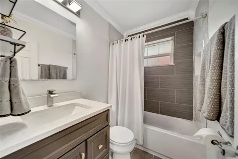 a bathroom with a sink a toilet a mirror and shower