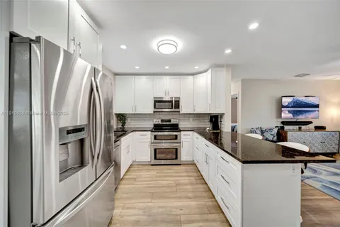 a kitchen with stainless steel appliances granite countertop a refrigerator and a stove